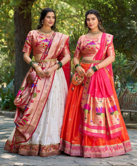Two women in traditional Indian sarees standing outdoors with greenery in the background